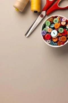 Image of close up of scissors, buttons and threads and copy space on cream 写真素材