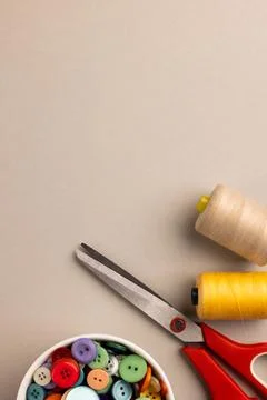 Image of close up of scissors, buttons and threads and copy space on cream Stock Photos