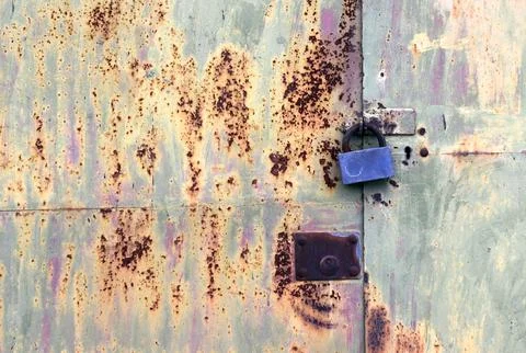 Image of a closed rusty double leaf metal gate of a room with a large padlock Stock Photos