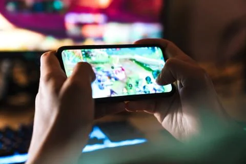 Image closeup of focused man playing video game on mobile phone Stock Photos