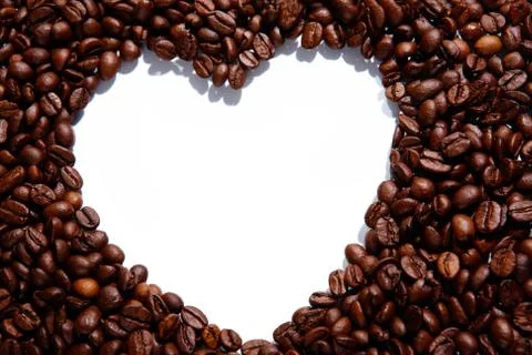 Image of coffee beans forming shape of heart on white background 스톡 사진