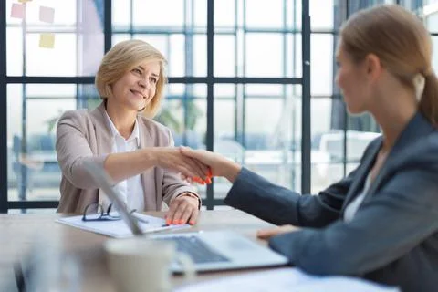 Image of collegues discussing documents and shaking hands. Stock-Fotos