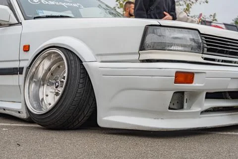 Image is a composite of two angles of a modified white compact car, possibly  Stock Photos