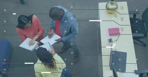 Image of computer language and lines, high angle view of diverse coworkers Stock Photos