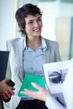 Image of confident businesswoman during interaction with her colleagues at meeti Stock Photos