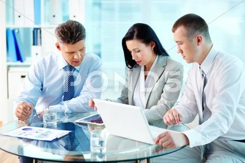 Image of confident partners working with modern communication device at meeting Stock Photos