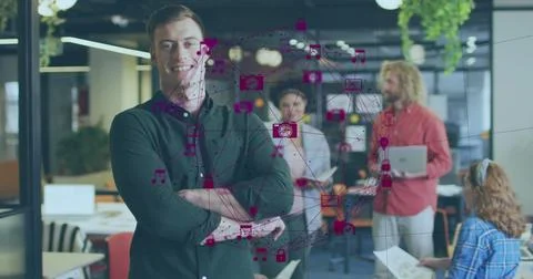Image of connected icons forming globe over smiling caucasian man standing with Stock Photos