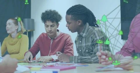 Image of connected icons forming globe over diverse coworkers sharing ideas in Stock Photos
