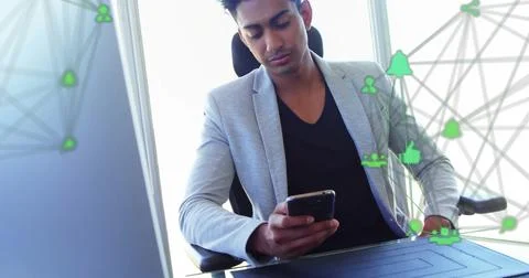 Image of connected icons globes over biracial man scrolling on smartphone at Stock Photos