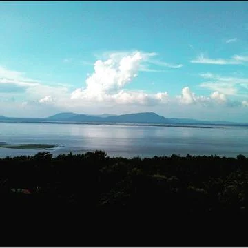 This image contains cloud pic and lake side view where they meet each other Stock Photos