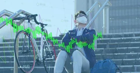 Image of data processing against asian man wearing face mask with laptop sitting Foto stock