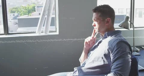 Image of data processing against thoughtful caucasian man sitting on his desk at 스톡 사진