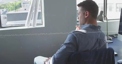Image of data processing against thoughtful caucasian man sitting on his desk at Stock Photos
