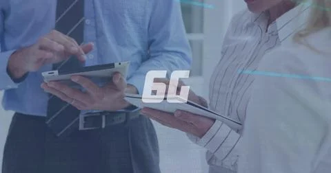 Image of data processing and 6g text over caucasian business people with tablet 库存照片