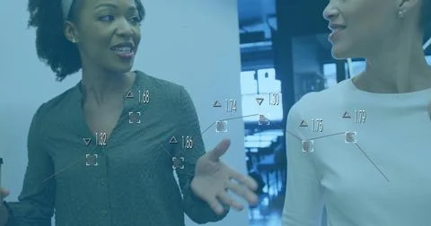 Image of data processing and diagrams over diverse female colleagues discussing Foto stock