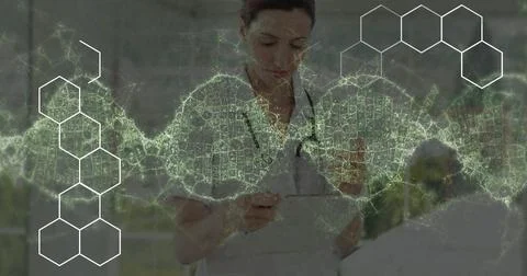 Image of data processing and dna strand spinning over caucasian female doctor Foto stock