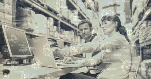 Image of data processing with icons man and woman using laptop in warehouse Foto stock