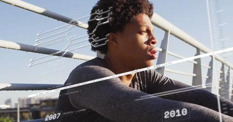 Image of data processing over african american man sitting Foto stock