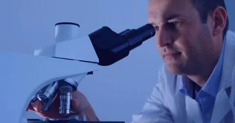 Image of data processing over caucasian male scientist using microscope Foto stock