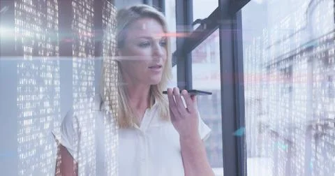 Image of data processing over caucasian businesswoman using smartphone in office Foto stock