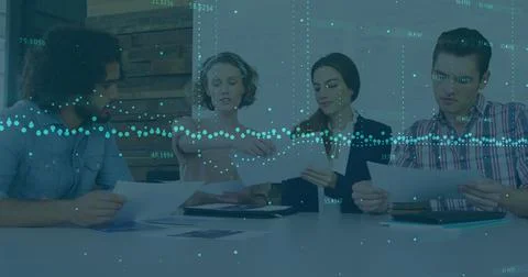 Image of data processing over diverse colleagues discussing over documents at Foto stock