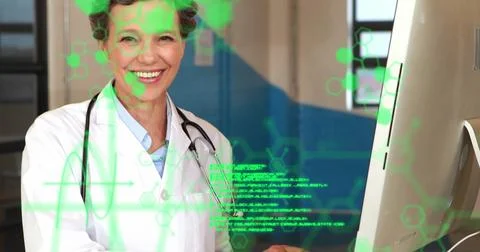 Image of data processing over happy caucasian female doctor using computer at Foto stock