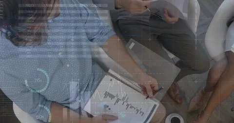 Image of data processing over mid section of diverse colleagues discussing over 库存照片