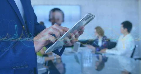 Image of data processing over mid section of businessman using digital tablet at 写真素材