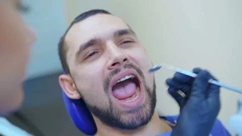 Image of dentist using angled mirror while examining patient's teeth Video stock 99002981