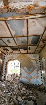 Image depicts a damaged building interior with fallen plaster, exposed beam.. Stock Photos
