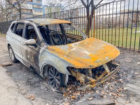 Image depicts a damaged car, possibly from an accident or fire, in an outdoor Stock Photos