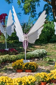 Image depicts a garden with three wind chimes, each of different design and c Stock Photos