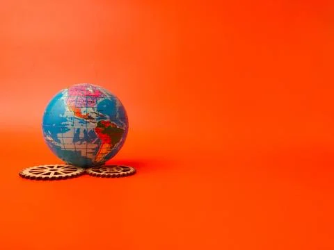The image depicts a globe resting on a bed of wooden gears, conveying a sen.. Stock Illustration