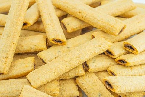Image depicts a stack of golden-brown, curved crackers with visible filling.. 写真素材