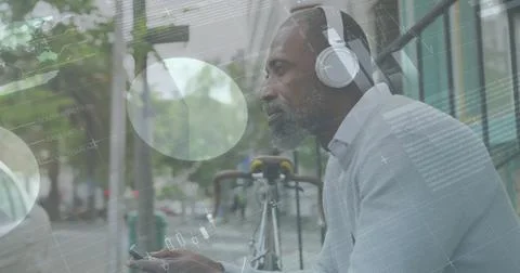 Image of diagrams and data processing over african american man listening to Stock Photos