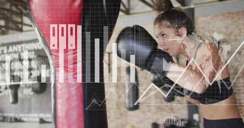 Image of diagrams and data processing over caucasian woman punching boxing bag Foto stock