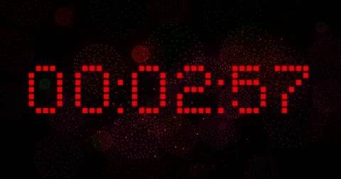 Image of digital clock counting down to midnight with fireworks on black Stock Photos