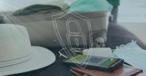 Image of digital padlock and shield over smartphone with qr code, luggage, hat Foto stock