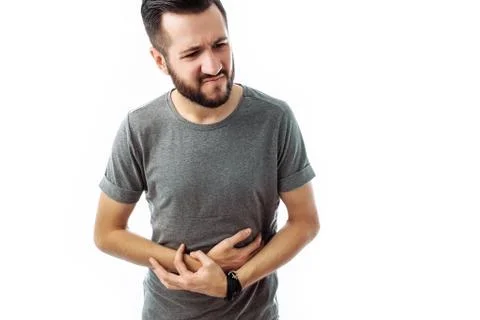 Image of a disgruntled young man with a beard, with painful feelings, holding Stock Photos