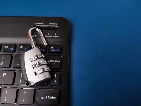 The image displays combination padlockresting on a computer keyboard, symbo.. Stock Photos