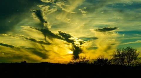 The image displays crepuscular rays, which are bands of light fanning out f.. Stock Photos
