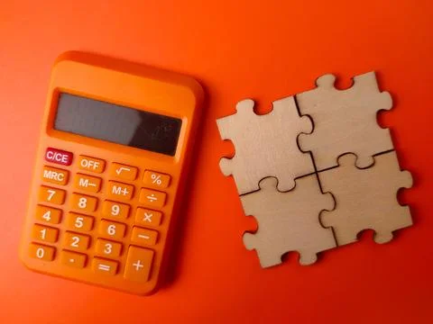 The image displays a small orange electronic calculator alongside four inte.. Stock Photos