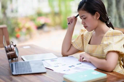 Image of document with charts on background of male and female working , busi Stock Photos