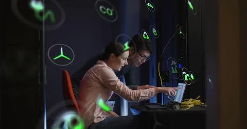 Image of eco icons and data processing over diverse business people by computer Stock Photos