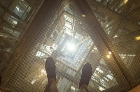 Image of an elevator shaft seen from above on safety glass Stock Photos