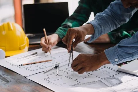 Image of engineering objects on workplace with three partners interacting o.. Stock Photos