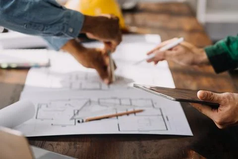 Image of engineering objects on workplace with three partners interacting o.. Foto stock