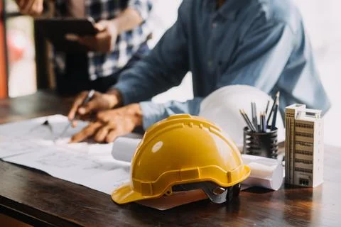 Image of engineering objects on workplace with three partners interacting o.. Stock Photos