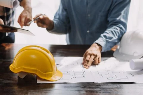 Image of engineering objects on workplace with three partners interacting o.. Foto stock