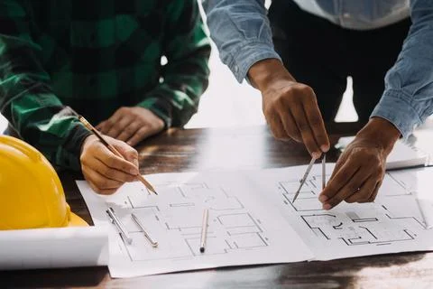 Image of engineering objects on workplace with three partners interacting o.. Foto stock